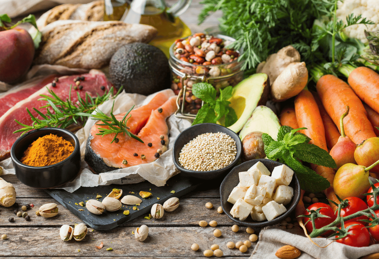 A table filled with healthy food items like salmon, quinoa, vegetables, and nuts, representing a balanced diet.