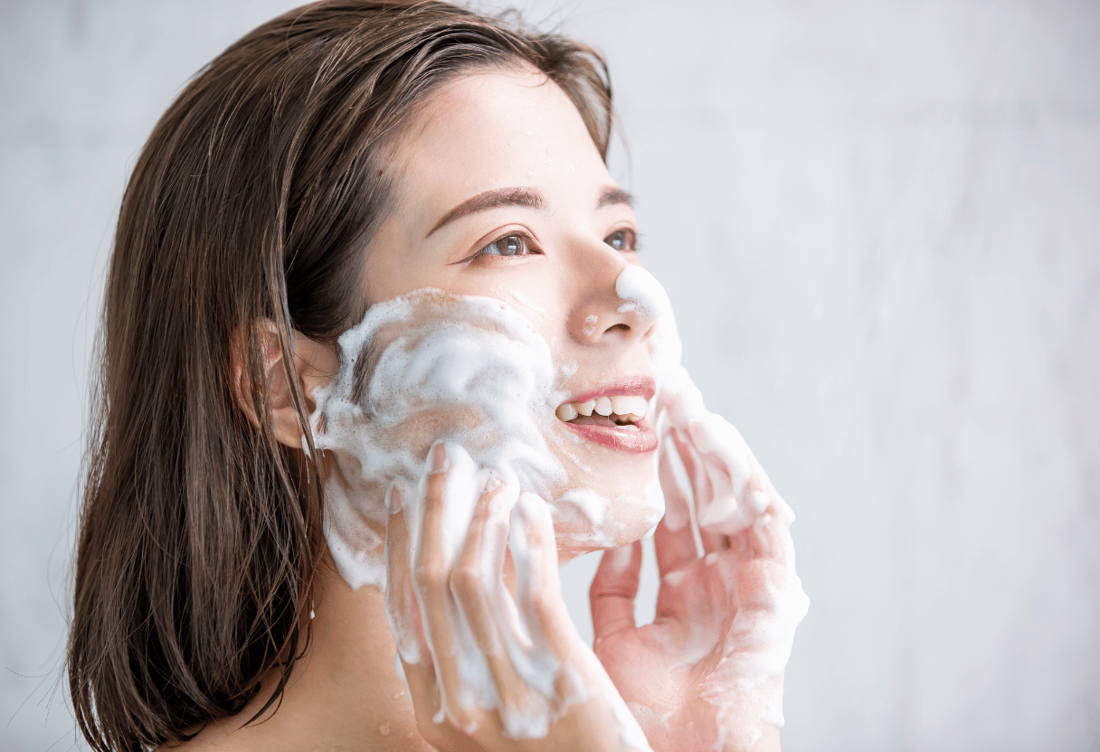 A woman enjoying a refreshing facial cleanse with a gentle foam cleanser.