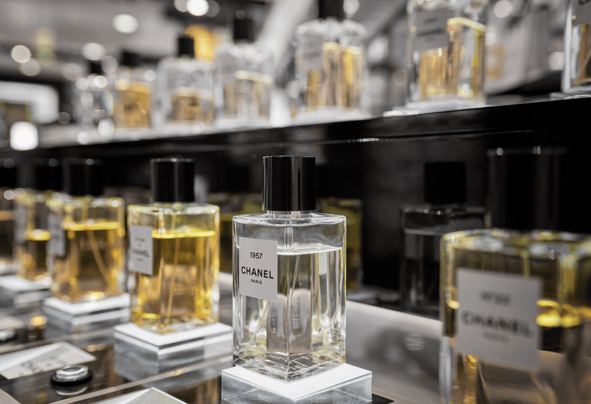 A display of Chanel perfumes stored elegantly on a shelf, showcasing various bottles in a professional setup.