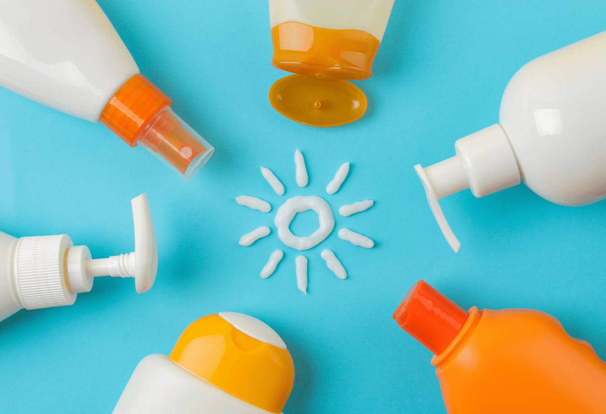 Sunscreen bottles arranged creatively with a sun shape made of cream